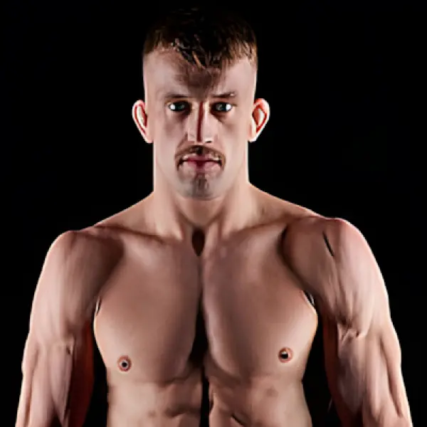Homme musclé à l'expression sérieuse, torse nu sur fond noir. Sa silhouette robuste et son regard concentré expriment détermination et force.
